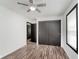 Bedroom featuring wood-look floors, white walls, closet, open door, and a window at 8041 Barry Rd, Indianapolis, IN 46219