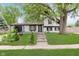 Charming home with lush green lawn, stone walkway, and mature shade tree in the front yard at 8041 Barry Rd, Indianapolis, IN 46219
