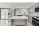 Modern kitchen with stainless steel appliances, gray cabinetry, and island with marble countertops at 8041 Barry Rd, Indianapolis, IN 46219
