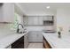 Close-up of kitchen showcasing gray cabinetry, stylish countertops, stainless steel appliances, and modern faucet at 8041 Barry Rd, Indianapolis, IN 46219