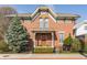 Charming brick home featuring a landscaped front yard and architectural details on a sunny day at 902 N College Ave, Indianapolis, IN 46202