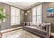 Stylish living room features a plush chaise lounge, decorative pillows, and unique lighting fixture, creating a cozy and inviting space at 902 N College Ave, Indianapolis, IN 46202