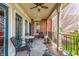 Cozy covered porch with slate flooring, wrought iron railings, and seating area overlooking the yard at 902 N College Ave, Indianapolis, IN 46202
