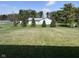 View of a green lawn with a shed surrounded by evergreen trees in the backyard at 990 Sunchaser Rd, Lebanon, IN 46052