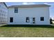 Back exterior view of the home showcasing the white siding and backyard lawn at 990 Sunchaser Rd, Lebanon, IN 46052