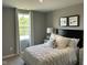 Bright bedroom features a plush white bed with decorative pillows, bedside table, and natural light from the window at 990 Sunchaser Rd, Lebanon, IN 46052