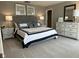 Bedroom with a gray upholstered headboard, dresser with mirror, and black and white accents at 990 Sunchaser Rd, Lebanon, IN 46052