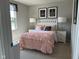 Inviting bedroom featuring a pink, ruffled comforter, chandelier art, and bedside lamps at 990 Sunchaser Rd, Lebanon, IN 46052