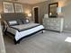 Bedroom with a gray upholstered headboard, dresser with mirror, and black and white accents at 990 Sunchaser Rd, Lebanon, IN 46052
