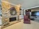 Charming living room with a stone fireplace, built-in shelving, and a comfortable chair, perfect for relaxing at 107 Knoll Ct # F, Noblesville, IN 46062