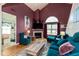 Bright living room boasts high ceilings, a fireplace, and stylish plum-colored walls at 10820 Washington Bay Dr, Fishers, IN 46037