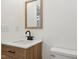 Bathroom vanity with wood cabinet, white countertop, dark faucet, and warm toned mirror at 1158 Burdsal Pkwy, Indianapolis, IN 46208