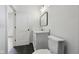 Modern bathroom featuring a white vanity with marble countertop, black framed mirror, and dark flooring at 1158 Burdsal Pkwy, Indianapolis, IN 46208