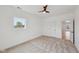 Bright bedroom includes a ceiling fan, neutral carpet, and a large window at 1158 Burdsal Pkwy, Indianapolis, IN 46208