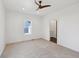 Bright bedroom features a ceiling fan, neutral carpet, and a sunny window at 1158 Burdsal Pkwy, Indianapolis, IN 46208