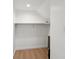 Walk in closet with wood laminate flooring and white walls with shelves at 1158 Burdsal Pkwy, Indianapolis, IN 46208