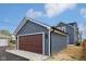 Detached garage with new construction, matching the house with blue siding and modern lighting at 1158 Burdsal Pkwy, Indianapolis, IN 46208