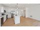 Modern kitchen with island, stainless steel appliances, and open view into a large living space with luxury vinyl plank flooring at 1158 Burdsal Pkwy, Indianapolis, IN 46208