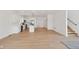 Bright, open-concept living space featuring a modern kitchen with an island and stainless-steel appliances, adjacent to a staircase at 1158 Burdsal Pkwy, Indianapolis, IN 46208