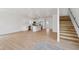 Bright, open-concept living space featuring a modern kitchen with an island and stainless-steel appliances, adjacent to a staircase at 1158 Burdsal Pkwy, Indianapolis, IN 46208