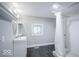 Bright bathroom featuring shower, vanity, mirror and contemporary gray vinyl flooring at 117 W Arizona St, Indianapolis, IN 46225