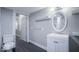 Well-lit bathroom featuring a modern vanity, oval mirror, and white shelving at 117 W Arizona St, Indianapolis, IN 46225