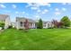 Backyard boasts a lush green lawn, perfect for outdoor activities and relaxation, surrounded by trees and landscaping at 12821 Gloria Dr, Fishers, IN 46037