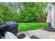 Serene backyard featuring a well-maintained lawn, mature trees, and a patio with outdoor seating and grilling area at 12821 Gloria Dr, Fishers, IN 46037