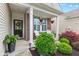 Inviting front porch with seating, decorative hanging plants, and attractive front door at 12821 Gloria Dr, Fishers, IN 46037