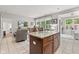 Kitchen island with seating adjacent to a living room with large windows for natural light at 12821 Gloria Dr, Fishers, IN 46037