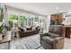 Well lit living room with neutral colors, modern furniture and connections to sunroom and kitchen at 12821 Gloria Dr, Fishers, IN 46037