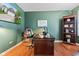 Home office featuring built-in shelving and a large desk with hardwood floors at 12821 Gloria Dr, Fishers, IN 46037