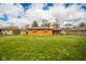 Lush backyard showcasing a well-kept lawn and brick home with a sunroom, providing a serene outdoor space at 1507 Lynnwood Dr, Anderson, IN 46012