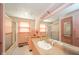 Retro pink-tiled bathroom with a large vanity and shower-tub combination at 1507 Lynnwood Dr, Anderson, IN 46012