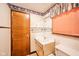 Bathroom with a single sink, a toilet, and a wood-paneled door at 1507 Lynnwood Dr, Anderson, IN 46012