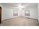 Bright bedroom with white walls, carpet floors, ceiling fan, and two windows at 1507 Lynnwood Dr, Anderson, IN 46012