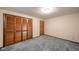 Bedroom showcases neutral walls, blue carpet, and a large closet with wooden doors at 1507 Lynnwood Dr, Anderson, IN 46012