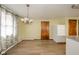 Dining area with wood-look flooring, modern chandelier, and easy access to kitchen at 1507 Lynnwood Dr, Anderson, IN 46012