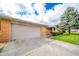 Spacious two-car garage and driveway leading to a brick home with mature landscaping at 1507 Lynnwood Dr, Anderson, IN 46012