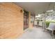 Covered front porch with brick siding and neutral-colored chairs at 1507 Lynnwood Dr, Anderson, IN 46012