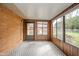 Enclosed sunroom with brick accent wall, tile floors, and large windows offering natural light and backyard views at 1507 Lynnwood Dr, Anderson, IN 46012