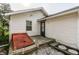 Back of the house with white siding and a small concrete patio and red basement door at 1510 Asbury St, Indianapolis, IN 46203