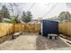 Enclosed backyard featuring a storage shed and stone benches on a concrete patio at 1510 Asbury St, Indianapolis, IN 46203
