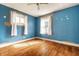 Bedroom with hardwood floors, two windows, and light blue painted walls at 1510 Asbury St, Indianapolis, IN 46203