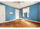Bedroom with hardwood floors, closet, window, and light blue painted walls at 1510 Asbury St, Indianapolis, IN 46203
