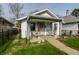 Charming single-Gathering home with a cozy front porch, landscaped with flowers, and a well-maintained lawn at 1510 Asbury St, Indianapolis, IN 46203