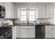 Charming kitchen featuring white cabinets, stainless steel appliances, and a view from the window at 157 E 61St St, Indianapolis, IN 46220