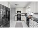 Well-lit kitchen with white cabinets, black appliances, and black marble countertops at 157 E 61St St, Indianapolis, IN 46220