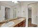 Well-lit bathroom featuring double sinks, a large mirror, and wood-look flooring at 16271 Ambia Cir, Westfield, IN 46074