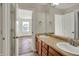 Bathroom with double sinks, wood-look flooring and view to adjacent bedroom at 16271 Ambia Cir, Westfield, IN 46074